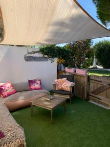patio z kanapą i stołem na zielonym trawniku w obiekcie Le mas des mourguettes w Saintes-Maries-de-la-Mer