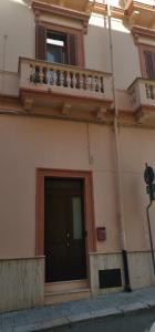 a building with a black door and a balcony at Sweet Aura in Brindisi
