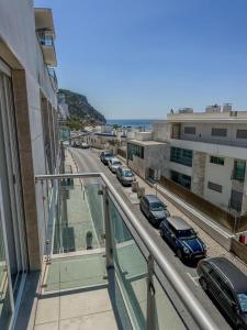 a balcony with a view of a street with parked cars at Casa do Sal in Sesimbra
