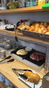 a counter with a bunch of bread and pastries at Best Western Hotel de la plage Normandie in Asnelles +26 photos