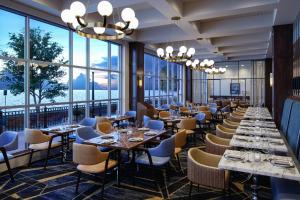 um restaurante com mesas e cadeiras e janelas grandes em Sheraton Erie Bayfront Hotel em Erie