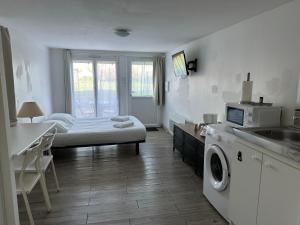 a room with a bed and a kitchen with a washing machine at Tours, Touraine et Chateaux de la Loire in Fondettes