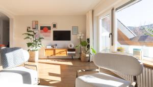 sala de estar con 2 sillas y TV en WÄLDER: Quartier Birkle in Titisee, en Titisee-Neustadt