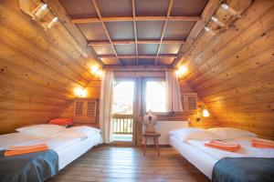 1 dormitorio con 2 camas en una habitación de madera en Klimatyczna Chatka u Podnóża Góry en Porąbka