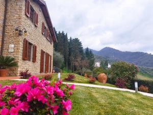 una casa con flores rosas en el patio en Villa Camelia Tuscany, en Pescia