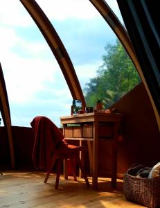 Zimmer mit einem Tisch und einem Stuhl in einem Zelt in der Unterkunft Le Mobil'Dôme à Marie in Cambounès