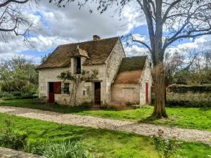 an old stone house with a tree in the yard at les épis de la joie in Ligueil