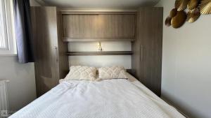 a bed with two pillows on top of it at Recreatie Chalet Oostkapelle VZ652 in Oostkapelle