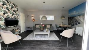 a living room with a couch and a table and chairs at Recreatie Chalet Oostkapelle VZ652 in Oostkapelle