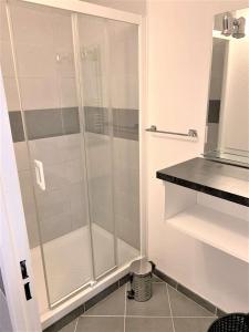 La salle de bains est pourvue d'une douche avec une porte en verre. dans l'établissement Appartement bien équipé à 500m plage et commerces à PERROS-GUIREC - Réf 948, à Perros-Guirec
