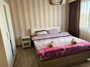 1 dormitorio con 1 cama con edredón rosa en Апарт Диана en Yambol