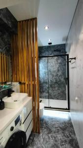 La salle de bains est pourvue d'un lavabo et d'une douche en verre. dans l'établissement ЖК Akay city. Новый ремонт, à Tachkent