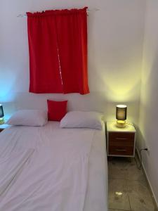 1 dormitorio con 1 cama con cortina roja en Caribbean Domicile, en Las Terrenas