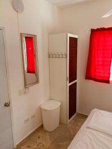 biała łazienka z toaletą i lustrem w obiekcie Caribbean Domicile w mieście Las Terrenas