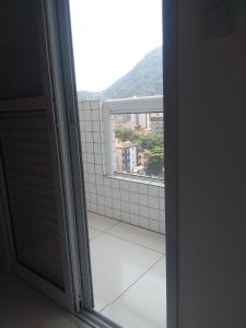 een open deur naar een badkamer met een raam bij Praia in Praia Grande