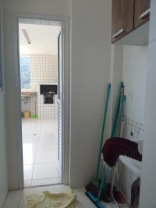 a room with a door open to a kitchen at Praia in Praia Grande