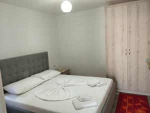 um quarto com uma cama branca com duas toalhas em ERTEO Guest House em Pogradec