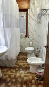 La salle de bains est pourvue de 2 toilettes et d'un lavabo. dans l'établissement Les Chambres, à Pagani
