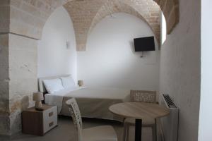 a bedroom with a bed and a table with a small table sidx sidx at b&b Olio su Pietra in Castellana Grotte