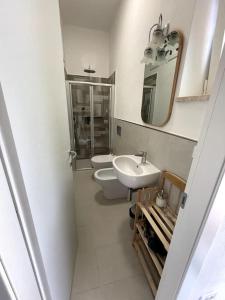 ein Badezimmer mit einem Waschbecken, einem WC und einem Spiegel in der Unterkunft Casa Dalidà in Tellaro