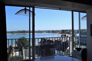 a room with a view of the ocean from a balcony at Appartement entièrement rénové avec SUPERBE VUE sur la Baie Sainte-Anne à TREGASTEL - Ref 96 in Trégastel