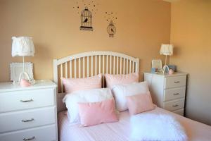 a bedroom with a bed with pink and white pillows at Appartement entièrement rénové avec SUPERBE VUE sur la Baie Sainte-Anne à TREGASTEL - Ref 96 in Trégastel