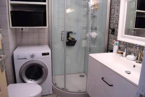 a bathroom with a washing machine and a sink at Appartement entièrement rénové avec SUPERBE VUE sur la Baie Sainte-Anne à TREGASTEL - Ref 96 in Trégastel +9 photos