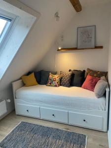 ein weißes Bett mit Kissen auf dem Dachboden in der Unterkunft Ferienwohnung am Kalkberg in Bad Segeberg