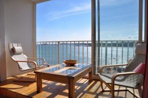 a balcony with a table and two chairs and a view of the ocean at Appartement avec SUPERBE VUE MER et terrasse, à 100m plages à TREGASTEL - Ref 97 in Trégastel