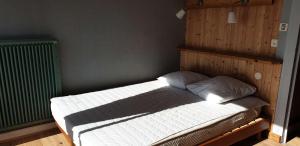 a bedroom with a bed with a wooden headboard at Appartement avec SUPERBE VUE MER et terrasse, à 100m plages à TREGASTEL - Ref 97 in Trégastel