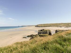 a beach with rocks and the ocean in the background at Perranglaze in Truro