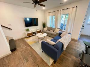 uma sala de estar com um sofá e uma televisão em Stylish townhome near AT&T Stadium, Globe Life, Six Flags & More em Arlington