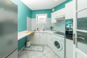 een wasmachine in een keuken met blauwe muren bij Le central in Mulhouse