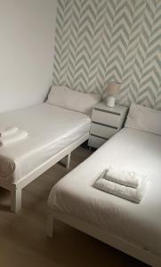 - deux lits assis l'un à côté de l'autre dans une pièce dans l'établissement 180 home Luxury Redes, à Séville