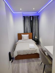 Schlafzimmer mit einem Bett mit lila Beleuchtung in der Unterkunft Vista Panorâmica RC Amadora in Amadora