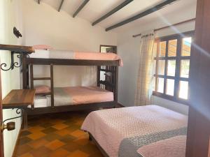 una habitación con dos literas y una ventana en CABAÑA VILLA SOFÍA RITOQUE, en Villa de Leyva