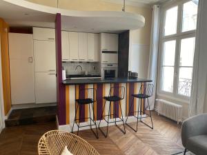 een keuken met een aanrecht en krukken in een kamer bij Une escapade au cœur de Tours in Tours