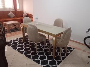 uma mesa de jantar e cadeiras com uma mesa e um tapete em الاسكندريه em Alexandria