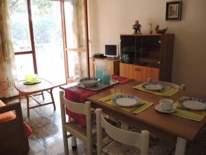a dining room with a wooden table with plates and candles at CAVALLINO in Bibione