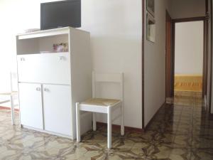 a white refrigerator and a stool in a room at CAVALLINO in Bibione