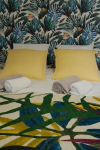 a bedroom with a bed with yellow pillows and a wallpaper at Aux portes du marché in Bar-le-Duc