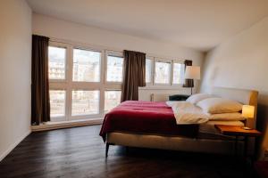 sypialnia z łóżkiem i dużym oknem w obiekcie URBAN ISLAND I Riverside Apartments w Wiedniu