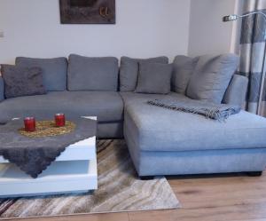 a living room with a blue couch and a table at Ferienwohnung Turmeck in Altenau