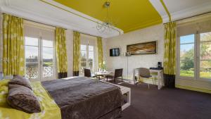 une chambre avec un lit, un bureau et des chaises dans l'établissement Hotel Les Hautes Roches, à Rochecorbon
