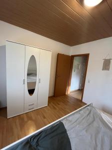 1 dormitorio con armario blanco y espejo en Relax Apartment, en Krumbach