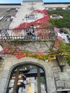 a building with a balcony with flowers on it at Hotel Sachsenklemme in Fortezza