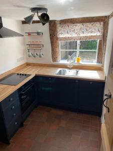 a kitchen with a sink and a window at Little Mouse Cottage in Lavenham