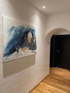 a painting of a man sitting at a table with a wine glass at Hotel Sachsenklemme in Fortezza