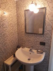 uma casa de banho com um lavatório e um espelho em A Casa di Sole Arese em Arese