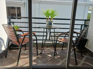 a table and chairs on a balcony with a potted plant at Andy's Place in Siem Reap